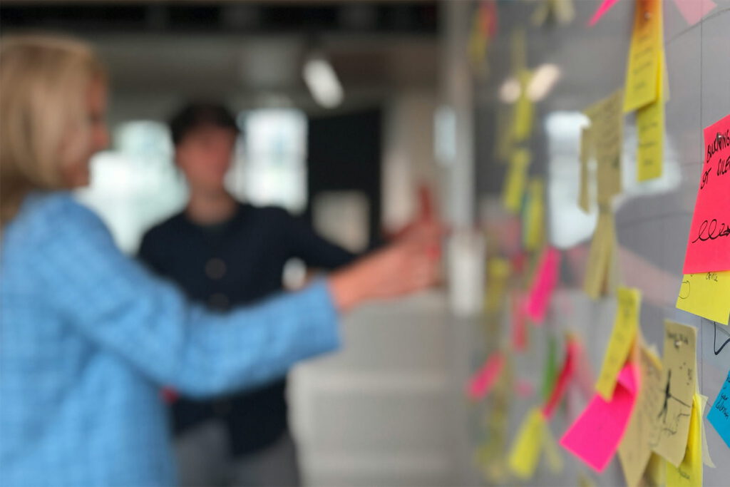 People placing sticky notes on a whiteboard